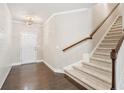 Bright entryway featuring hardwood floors, a stylish chandelier, and a staircase with wooden banister at 207 Magnolia Creek Way, Woodstock, GA 30188