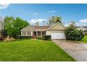 Inviting single-story home featuring a lush green lawn, complemented by mature trees and tasteful landscaping at 392 Beranda Cir, Douglasville, GA 30134