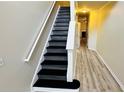 The staircase features a white handrail and black steps, seamlessly connecting different levels of the home at 4134 Rogers Creek Ct # 41, Duluth, GA 30096