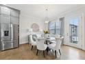 Cozy dining area with stainless steel refrigerator, seating for six, and hardwood flooring at 115 Harlow Cir, Roswell, GA 30076