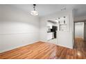 Dining room with wood floors, an open doorway to the kitchen, and modern pendant lighting at 1606 Vicksburg Pl, Atlanta, GA 30350
