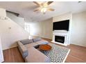 Bright living room features a fireplace, ceiling fan, and a sectional sofa with hardwood floors at 290 Brookview Dr, Riverdale, GA 30274