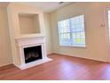 Living room view showcasing the fireplace, large window, and hardwood floors at 290 Brookview Dr, Riverdale, GA 30274