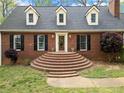 Inviting brick facade with multi-tiered steps leading to front door; dormer windows add curb appeal at 6695 Woodstock Rd, Acworth, GA 30102