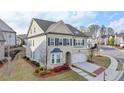 Aerial view of a charming two-story home featuring a two-car garage, a landscaped yard, and a mix of brick and siding exterior at 6585 Creekview Cir, Duluth, GA 30097