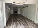 Bright, spacious living room with a fireplace, built-in shelving, and attractive wood-look flooring at 6921 Babbling Brook Dr, Rex, GA 30273