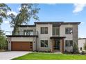 Beautiful modern home featuring a seamless two-car garage, balcony and stone accents, nestled in a lush green setting at 1604 Niskey Lake Sw Rd, Atlanta, GA 30331