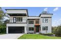Modern two-story home with a black garage door, white facade and landscaped yard, exuding contemporary elegance at 1610 Niskey Lake Sw Rd, Atlanta, GA 30331
