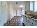 Kitchen featuring ample storage, a large window, with white cabinets and a contrasting floor at 5255 Biffle Downs Rd, Stone Mountain, GA 30088