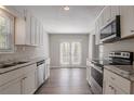 Bright kitchen featuring stainless steel appliances and double doors to the backyard at 477 Victoria Rd, Woodstock, GA 30189