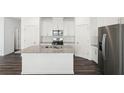 Modern kitchen featuring stainless steel appliances, a kitchen island, and white cabinets at 353 White Tail Rd, Stockbridge, GA 30253