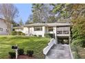 Ranch-style home with driveway and carport, surrounded by mature trees on a sunny day at 2506 Parkdale Ne Pl, Atlanta, GA 30305