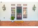Elegant front entrance featuring a dark door, white trim, sidelights, lantern sconces, and brick porch at 468 W Paces Ferry Rd, Atlanta, GA 30305
