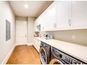 Well-lit laundry room featuring modern washer and dryer units, ample counter space, and white cabinetry at 0 Ebenezer Rd, Fayetteville, GA 30215