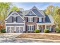 Charming brick and siding two-story home featuring a spacious two-car garage and well-manicured front lawn at 5848 Deer Crossing Dr, Sugar Hill, GA 30518