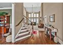 Elegant foyer with hardwood floors, staircase, and high ceilings leading to a bright living area at 5848 Deer Crossing Dr, Sugar Hill, GA 30518