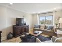 A well-lit living room with a comfortable sofa, large TV, and city view at 2285 Peachtree Ne Rd # 1207, Atlanta, GA 30309