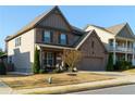 Attractive two-story home with brick and siding, showcasing a neat lawn and inviting front porch at 211 Orchard Trl, Canton, GA 30115