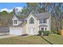 Charming two-story home with a two-car garage and well-manicured front lawn at 498 Pecan Wood Cir, Fairburn, GA 30213