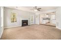 Open concept living room with fireplace seamlessly connects to modern kitchen at 498 Pecan Wood Cir, Fairburn, GA 30213