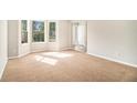 Bright living room featuring a bay window and neutral carpet at 498 Pecan Wood Cir, Fairburn, GA 30213