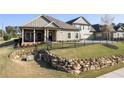 Charming home with green siding, a rock retaining wall, and a fenced yard at 57 Cedarcrest Village Ln, Acworth, GA 30101