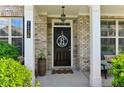 Inviting front entryway featuring a decorative door, brick facade, and well-maintained landscaping at 7130 Ansley Park Way, Cumming, GA 30028
