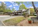 Exterior view of the townhome's front and attached carport with green space and bench at 2060 Clairmeade Ne Way, Atlanta, GA 30329