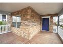 Covered front porch featuring stone facade, white railing and a blue door at 1852 E Farris Ave, Atlanta, GA 30344