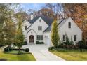 Charming two-story brick home with lush landscaping, mature trees, and a spacious driveway at 803 Courtenay Ne Dr, Atlanta, GA 30306