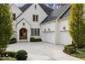 Elegant brick home featuring a two-car garage, arched doorway, and manicured landscaping at 803 Courtenay Ne Dr, Atlanta, GA 30306