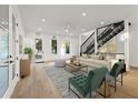 Bright living room featuring hardwood floors, a modern staircase, and large windows at 180 Railroad St, Canton, GA 30114