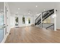 Bright living room featuring hardwood floors, a modern staircase, and large windows at 180 Railroad St, Canton, GA 30114