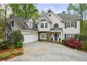 Elegant home with a manicured lawn, stone accents, multi-car garage, and a welcoming entrance at 460 Laurel Chase Ct, Atlanta, GA 30327