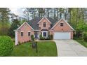 Beautiful two-story red brick home features a well-maintained lawn and an attached two-car garage at 740 Trillium Ln, Lilburn, GA 30047