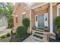 Inviting front entrance featuring a gray front door, stone steps, and lush landscaping at 740 Trillium Ln, Lilburn, GA 30047