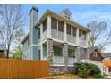 Two-story home with screened porches, stone accents, chimney and wood fence in a leafy setting at 1643 Wade Ne Ave, Atlanta, GA 30317