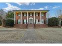 Stately brick home featuring white columns and dark shutters for an elegant look at 1909 Hickory Level Rd, Villa Rica, GA 30180