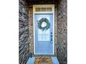Inviting front door with wreath and 'home sweet home' doormat, set in brick surround at 2930 Smith Ridge Trce, Peachtree Corners, GA 30071