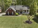 Well-maintained brick house with a large front yard and mature trees at 3100 Templeton Ln, Loganville, GA 30052
