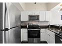 Bright kitchen showcases stainless steel appliances, white cabinets, and dark countertops at 2855 Peachtree Ne Rd # 115, Atlanta, GA 30305