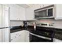 Kitchen featuring stainless steel appliances, white cabinets, and dark countertops at 2855 Peachtree Ne Rd # 115, Atlanta, GA 30305