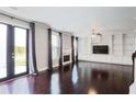 Open-concept living room boasting hardwood floors, custom built-ins, fireplace, and French door access to yard at 350 Marble Springs Rd, Lilburn, GA 30047