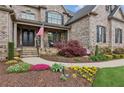 Charming front porch with stone steps, black wrought iron doors, and lush landscaping at 968 Woodtrace Ln, Auburn, GA 30011