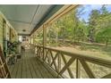 View of the inviting covered porch with wooden railings and a view of the landscaped yard at 10 Powder Dr, Dallas, GA 30157