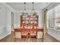 Formal dining room with wood table and chairs, modern lighting, and ample natural light at 4040 Grandview Manor Dr, Cumming, GA 30028