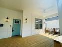 Covered front porch showcasing a wooden floor, a stylish blue door and classic wall-mounted lanterns at 851 Dill Sw Ave, Atlanta, GA 30310