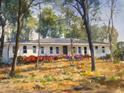 Charming single-story home with painted brick, colorful flower beds, and a wooded lot creating a serene setting at 2729 Ridge Valley Nw Rd, Atlanta, GA 30327