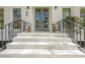 Elegant front entrance with brick steps, decorative iron railings, and a stylish sage-green front door at 2729 Ridge Valley Nw Rd, Atlanta, GA 30327