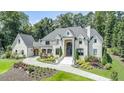 Stately brick home with manicured landscaping, circular driveway, and grand entrance, exuding curb appeal at 211 Meritage Dr, Alpharetta, GA 30022